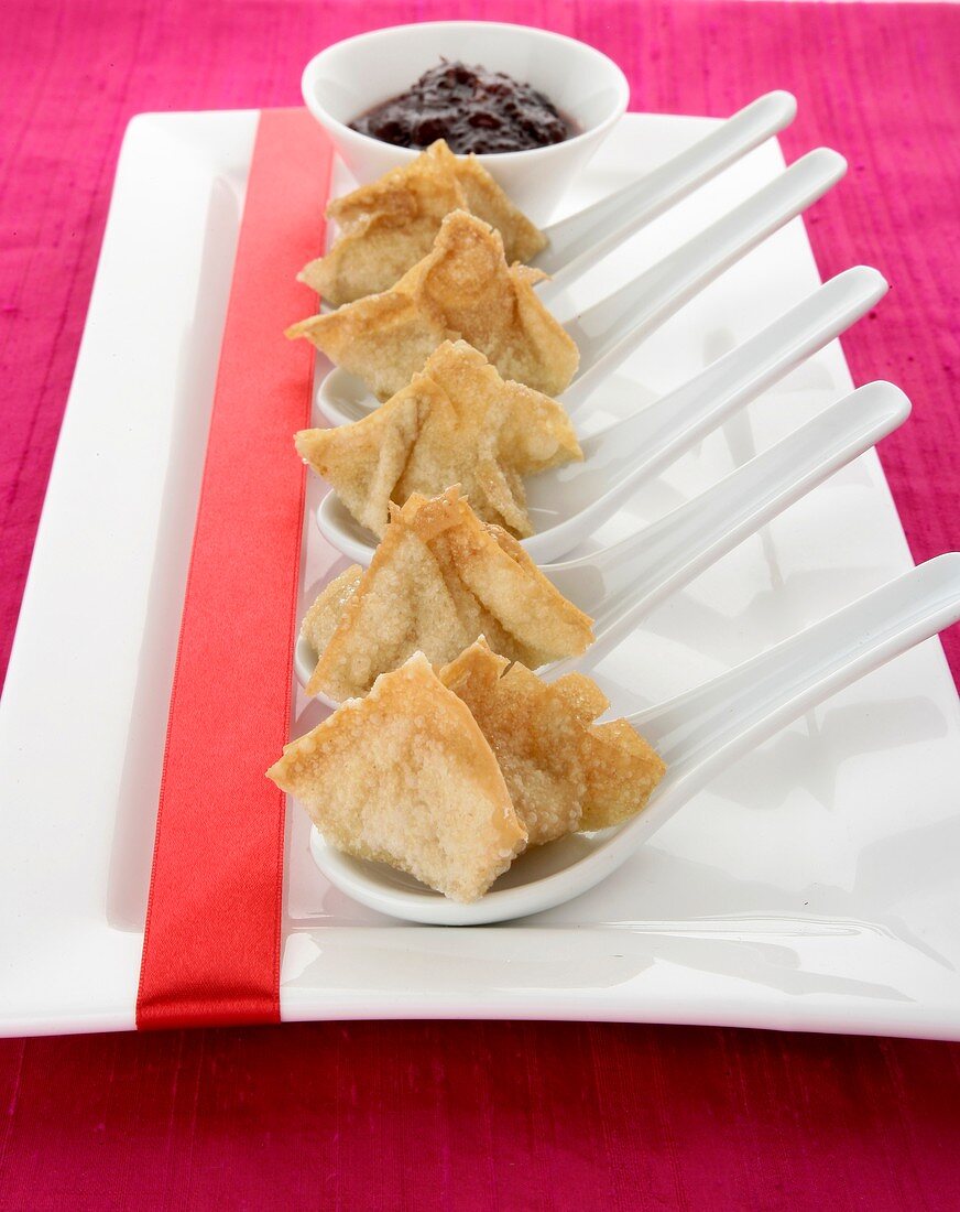 Wontons filled with surimi on spoons