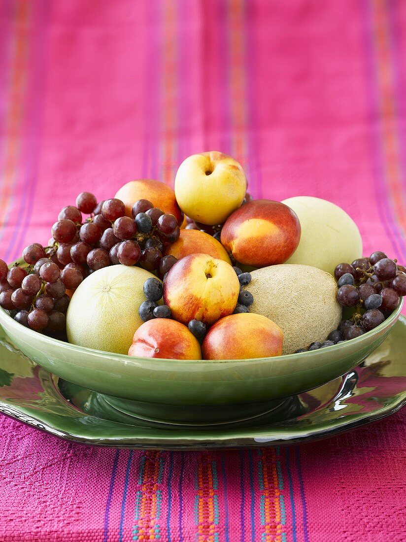 Melons, nectarines and grapes in fruit bowl
