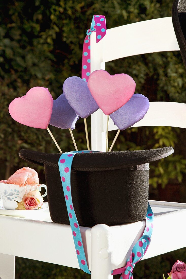 Herzförmige Lavendelplätzchen am Stiel in einem Hut (Mad Hatter Party)