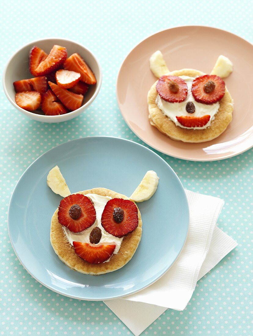 Lustige Gesichter aus Pancakes mit Erdbeeren