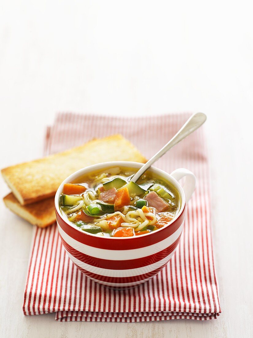 Noodle and vegetable soup with bacon