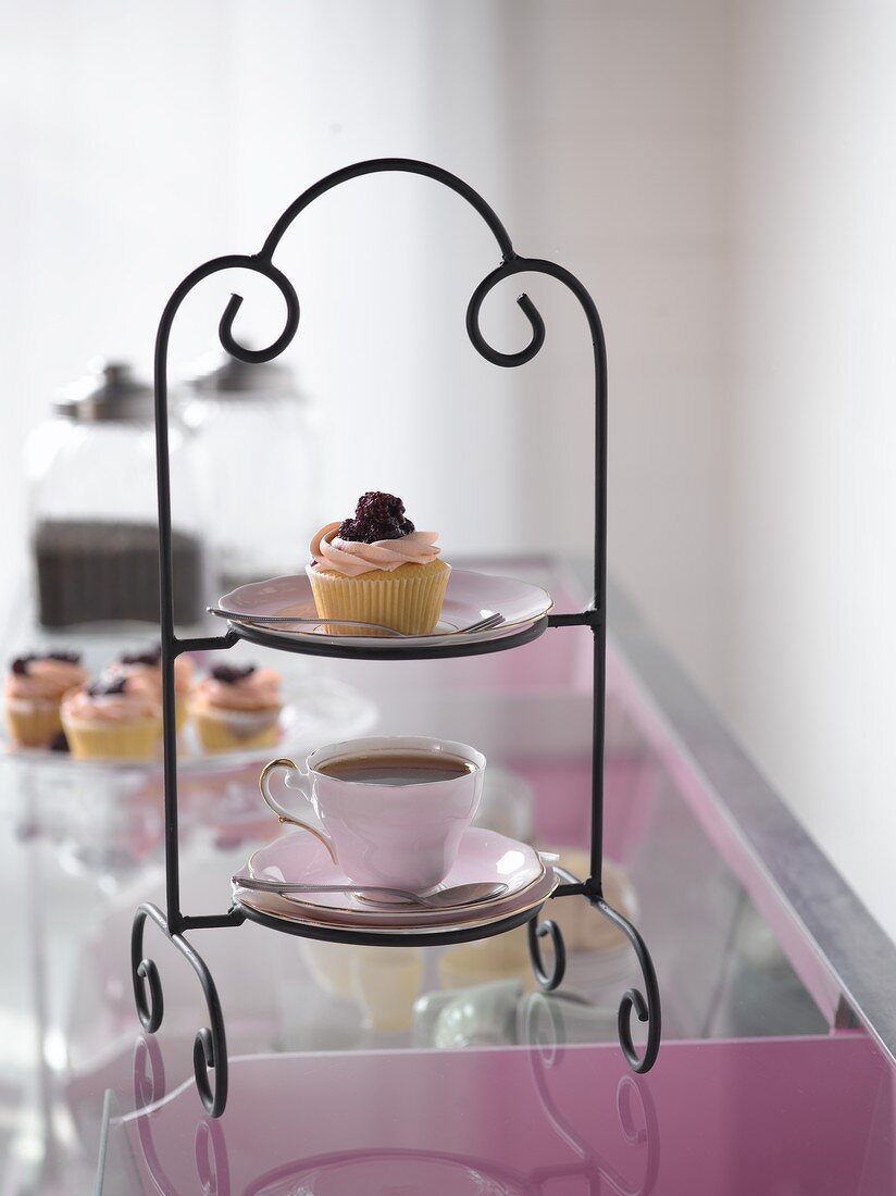 Etagere mit Cupcake und einer Tasse Tee