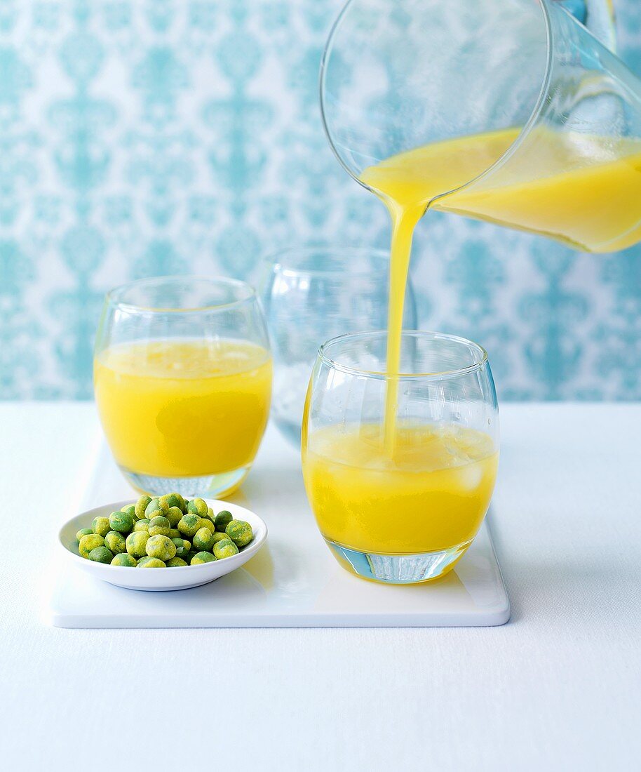 Mango-Gimlet in ein Glas einschenken