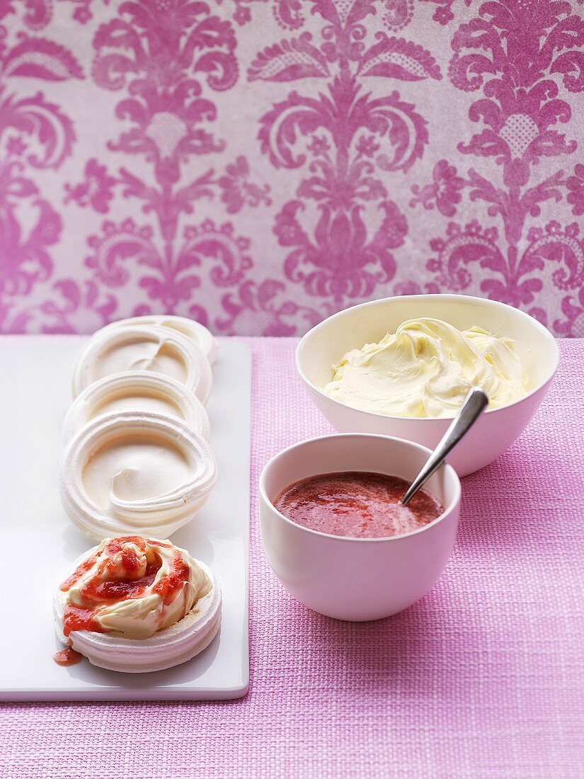 Meringue nests with strawberry coulis and cream