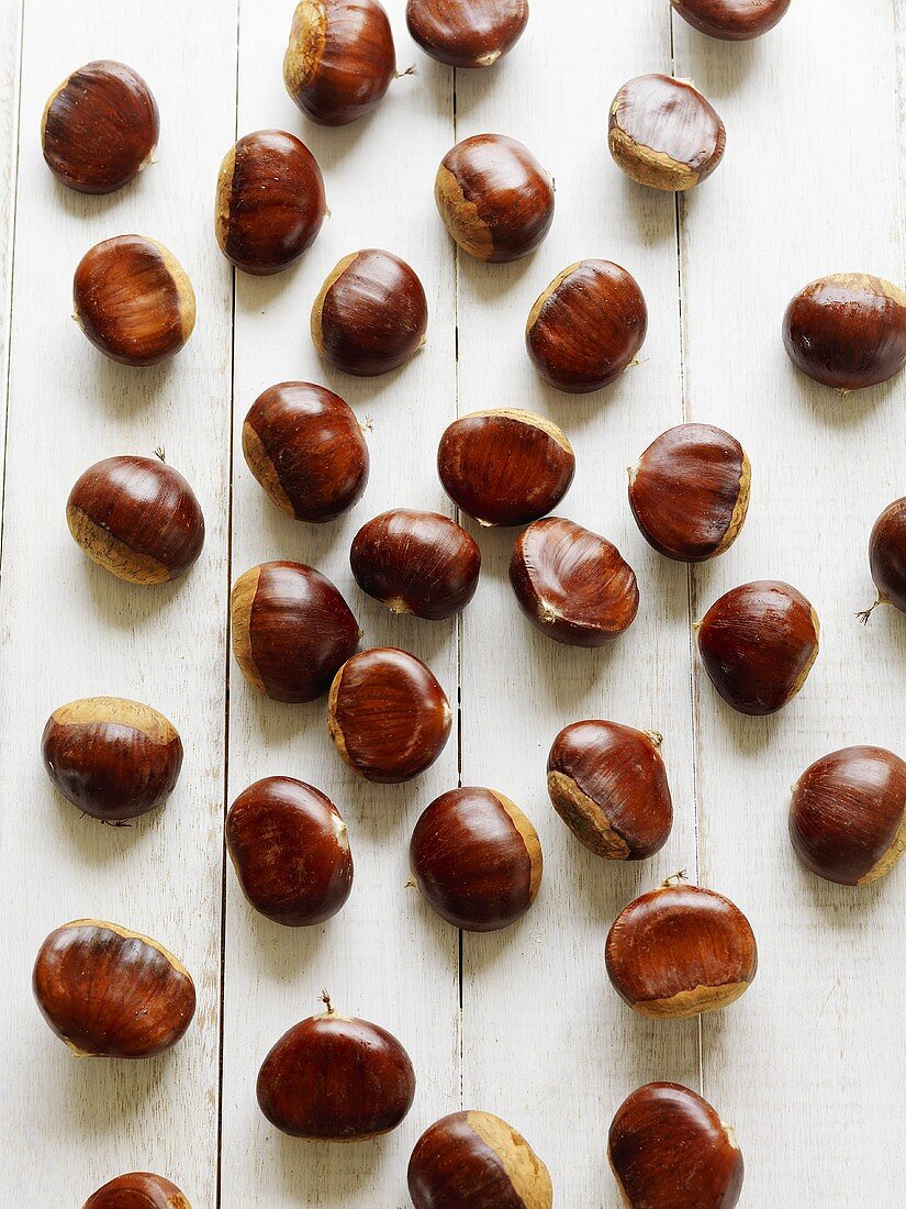 Chestnuts on white painted wooden background
