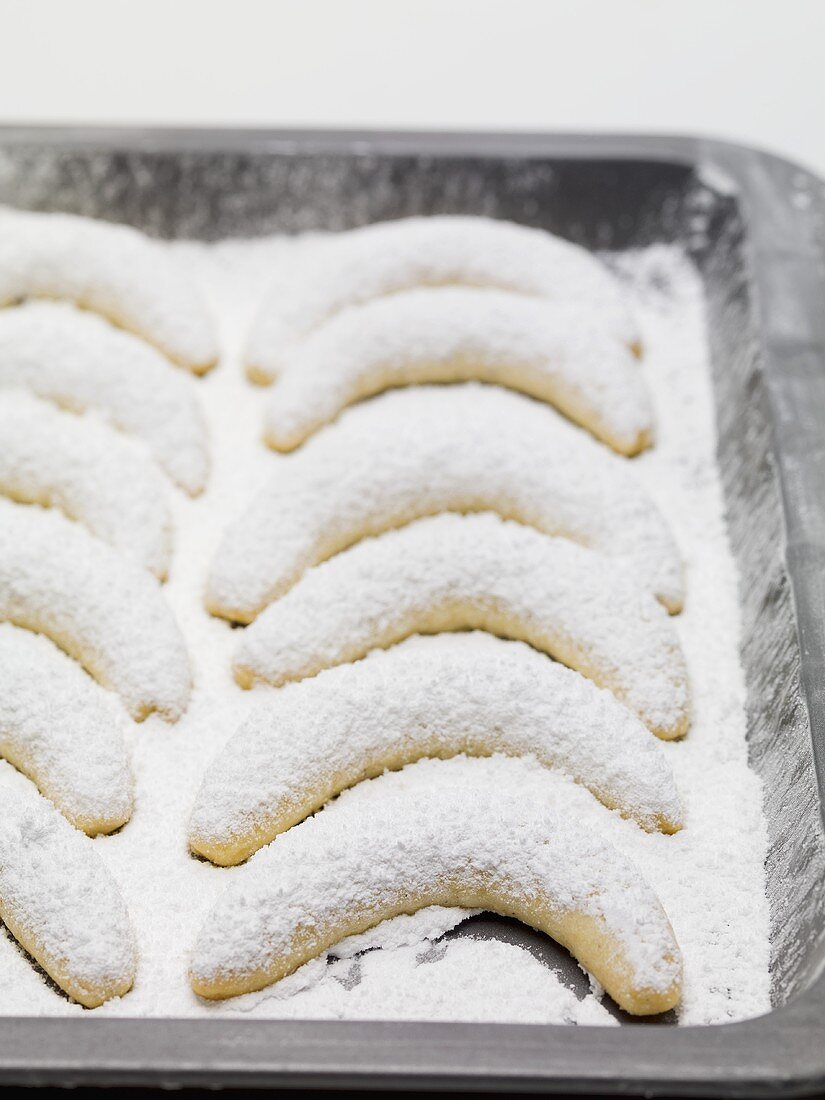 Vanillekipferl mit Puderzucker auf Backblech