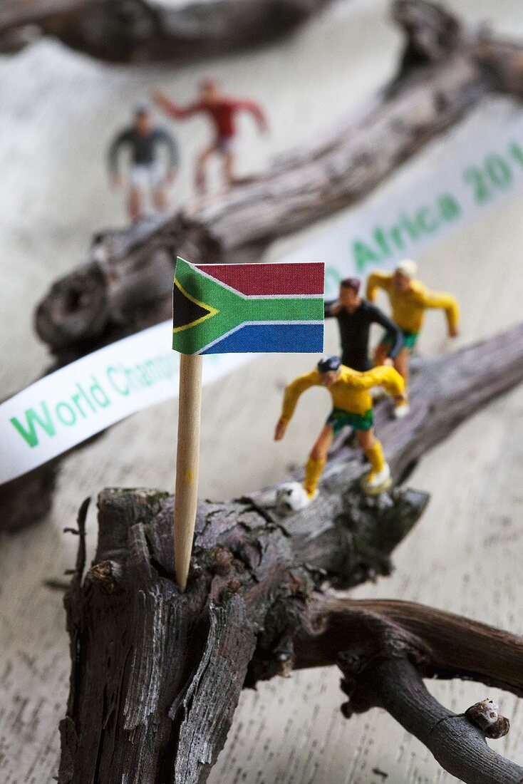 A miniature flag and toy football players on twigs