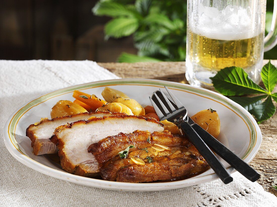 Roast pork with crackling with vegetables and beer