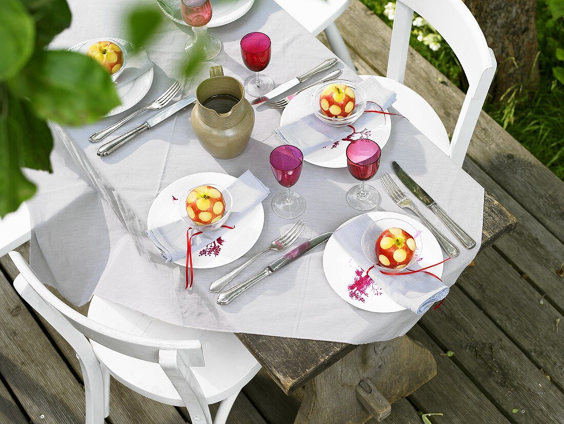 Laid table with apple decorations out of doors