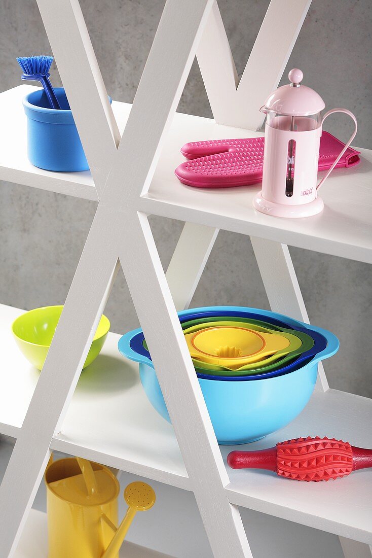 Assorted plastic kitchen utensils on shelves