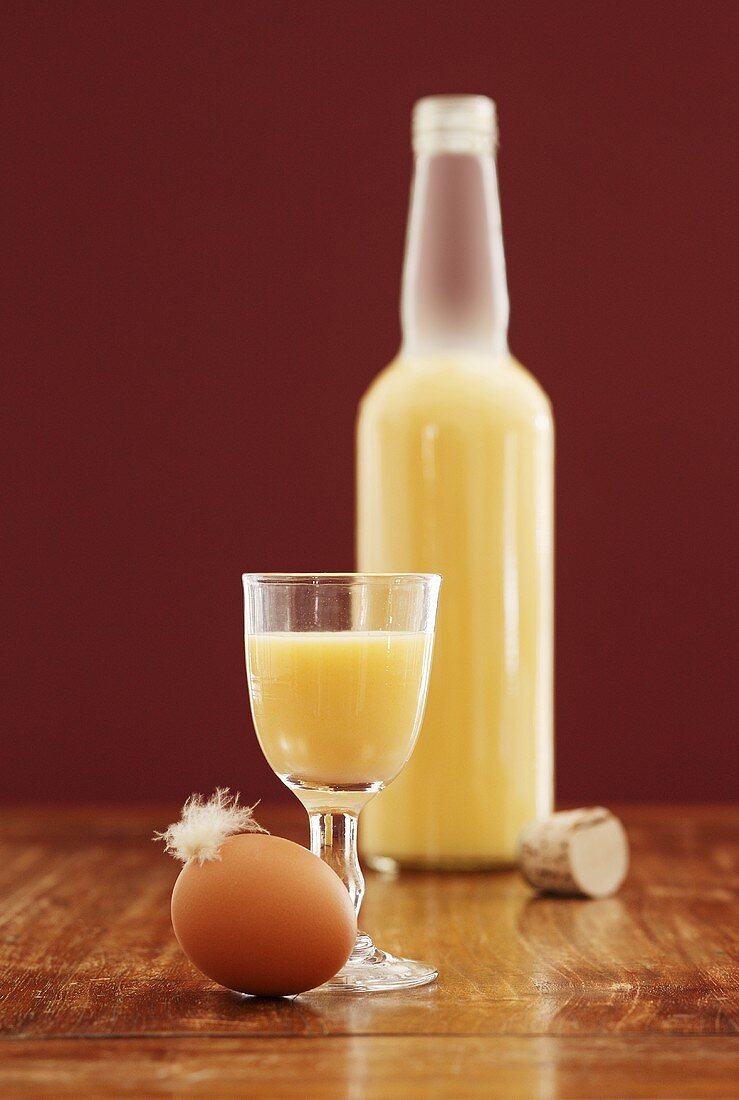 Eierlikör in Glas und Flasche, Ei mit Feder