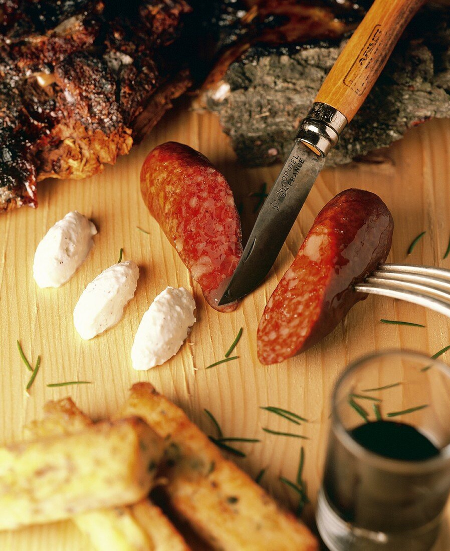 Diot (Schweinewurst) mit Pate, Polenta, Wein und Messer