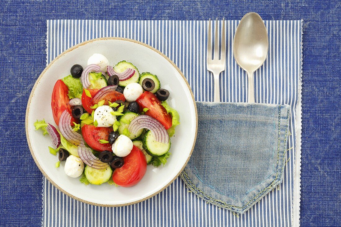 Tomato, cucumber and onion salad with mozzarella and olives