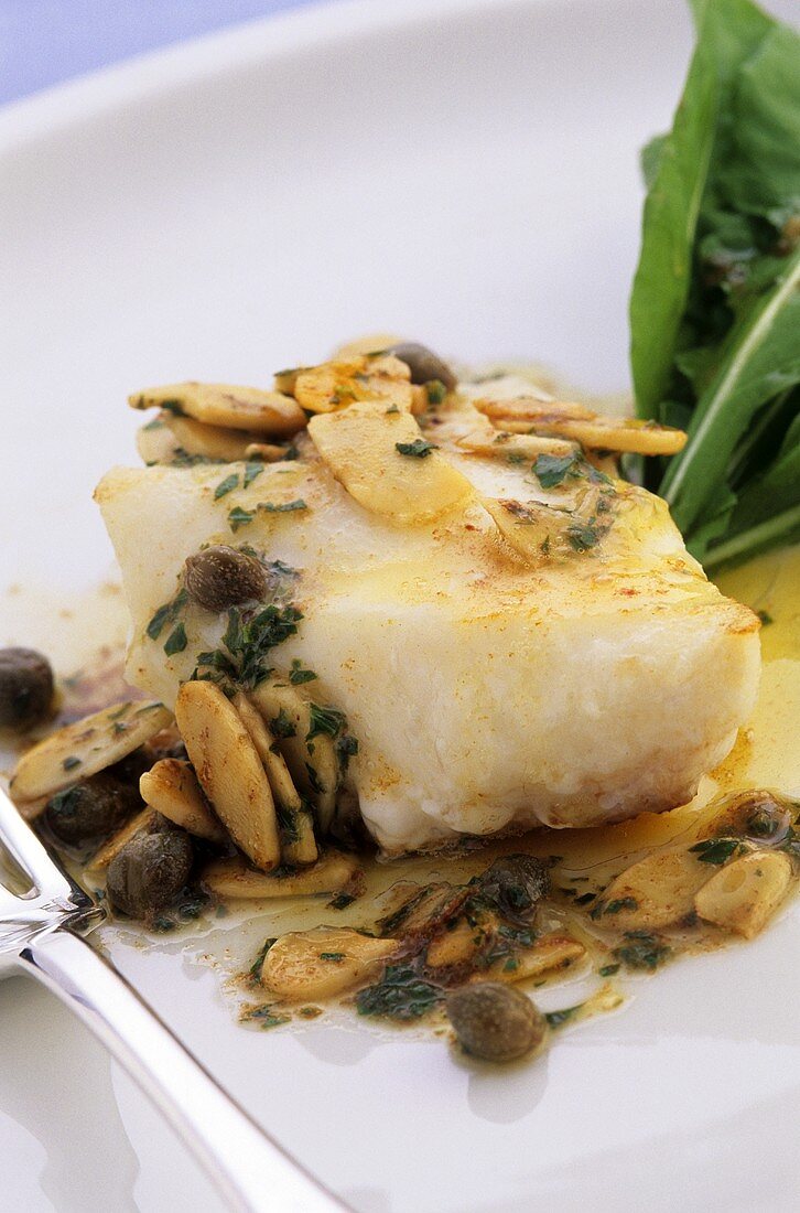 Fish fillet with lemon and caper sauce and flaked almonds