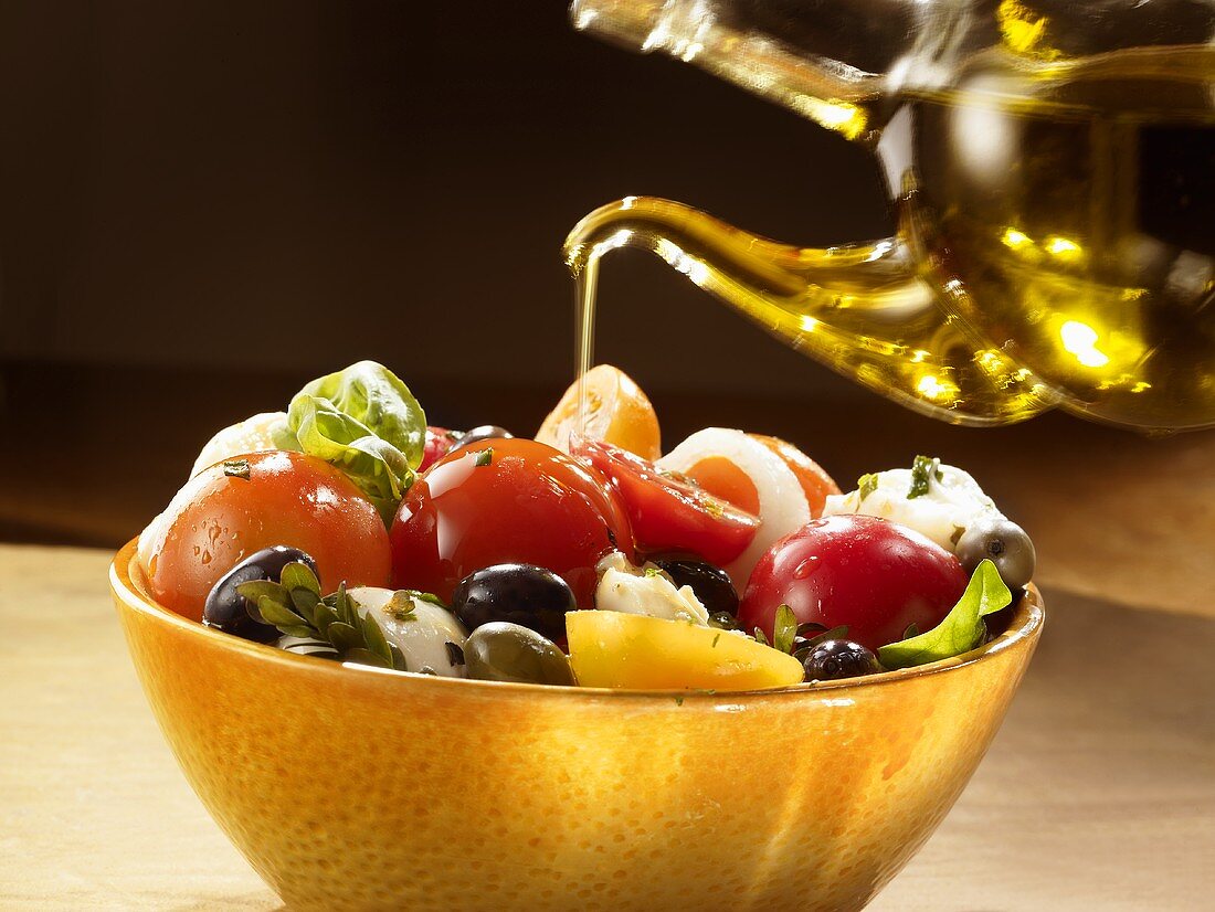 Insalata Caprese mit Olivenöl beträufeln