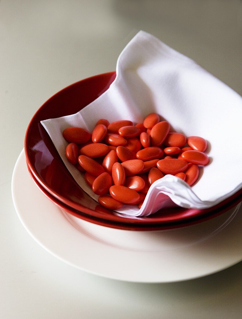 Red sweets on a serviette in a bowl