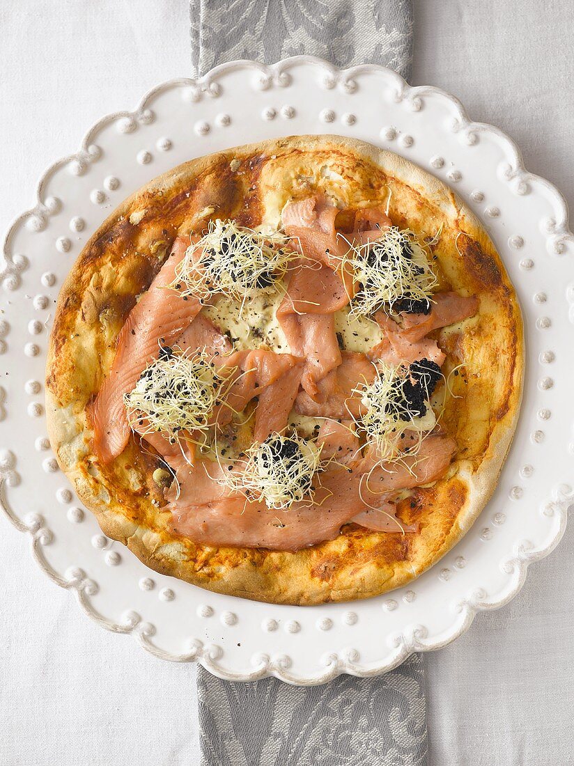 Pizza topped with smoked salmon, caviar and crème fraîche