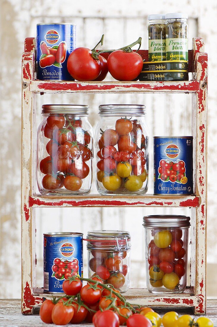 Fresh tomatoes in preserving jars and tins of tomatoes