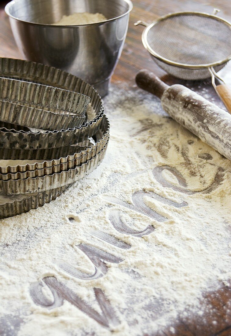 Baking utensils and the word 'quiche' written in flour