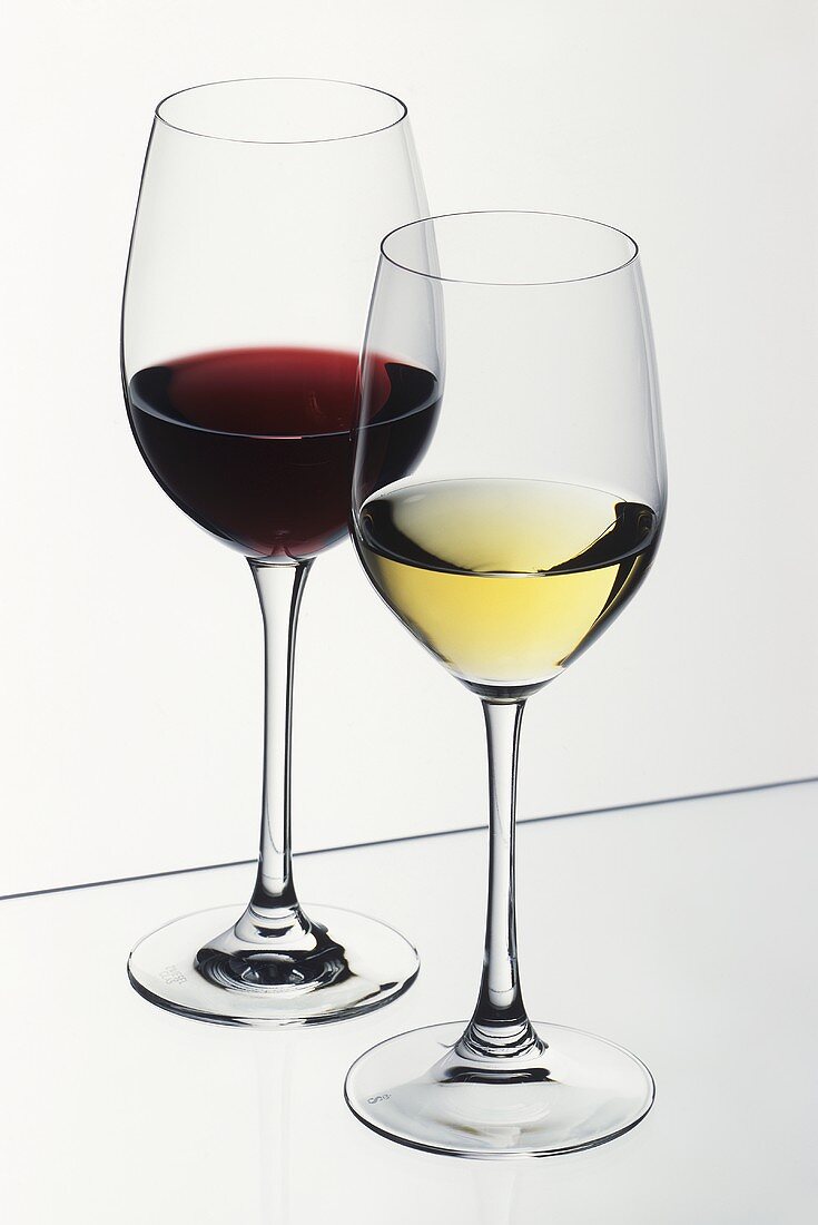 Glass of white wine in front of glass of red wine