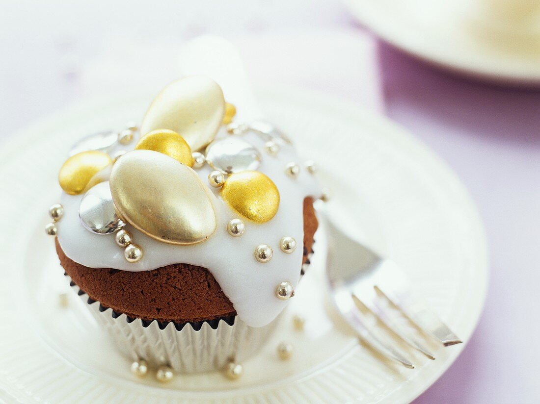 Iced chocolate muffin with gold chocolate almonds