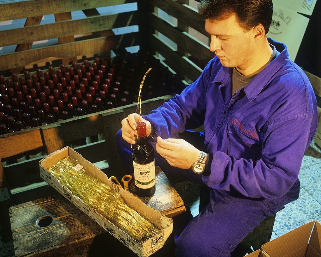 Weinflasche wird mit 'Alambrado' (Drahtgeflecht) eingebunden
