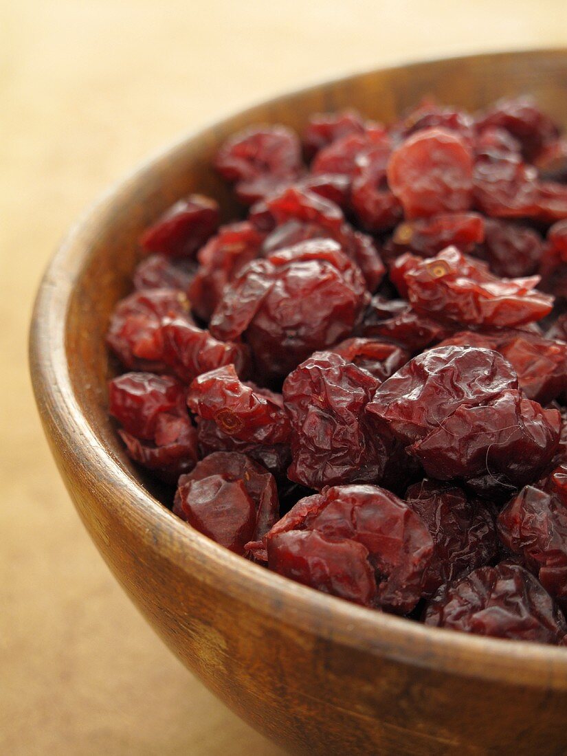 Dried cranberries in a wooden bowl (close-up)