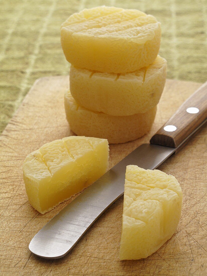 Harzer cheese on a chopping board with a knife
