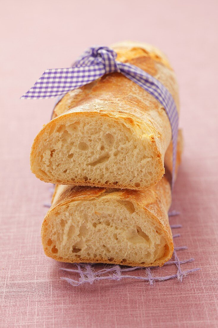 Zwei halbe Baguettebrote mit Band zusammen gebunden