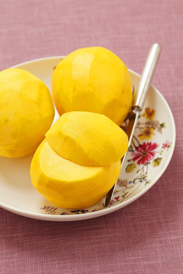 Three peeled mangos on a plate