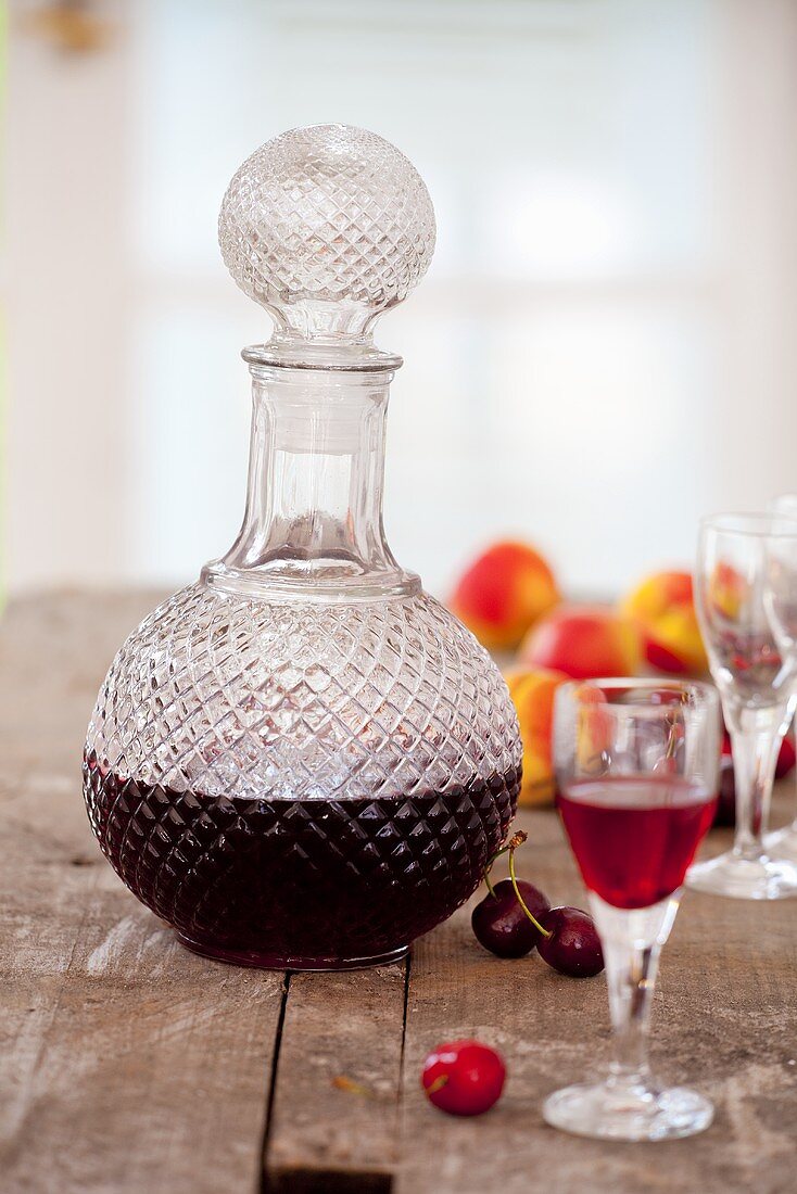 Homemade cherry and apricot liqueur in a carafe and a glass