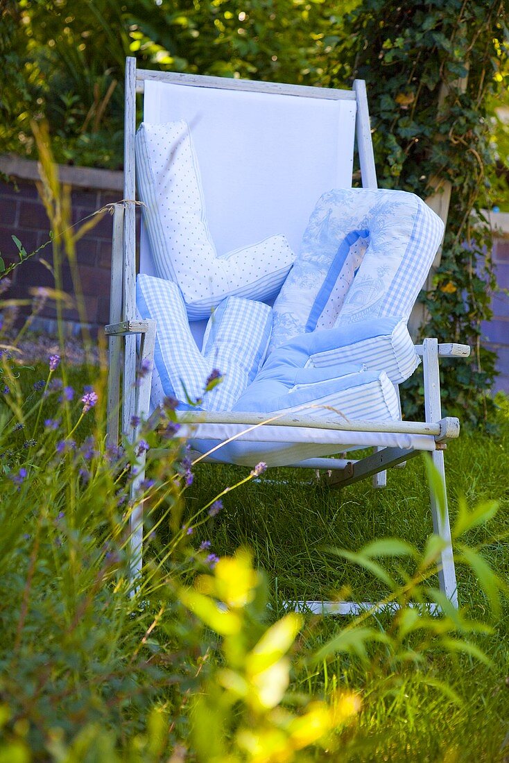 Blue deck chair in a garden with pillows which spell 'LOVE'