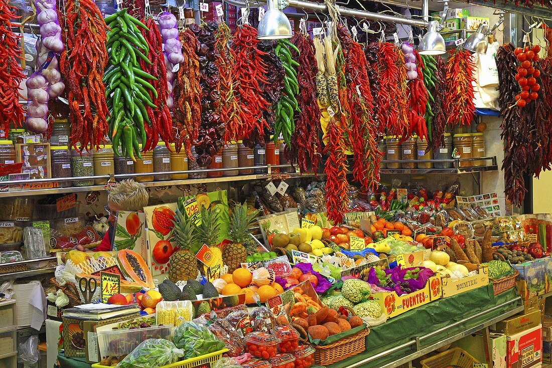 Marktstand mit Chilischoten, Knoblauch, Obst und Gemüse (Mercat de St. Josep (Boqueria), Ramblas, Barcelona, Spanien)