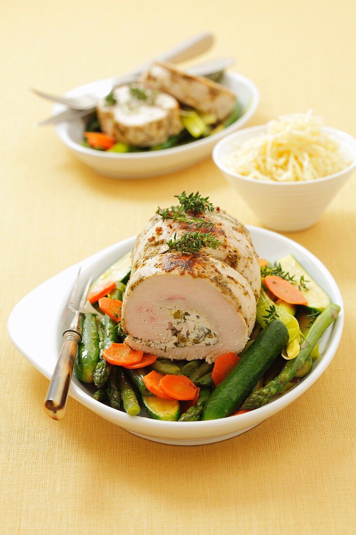 Turkey roulade with herb cheese and pea stuffing on vegetables
