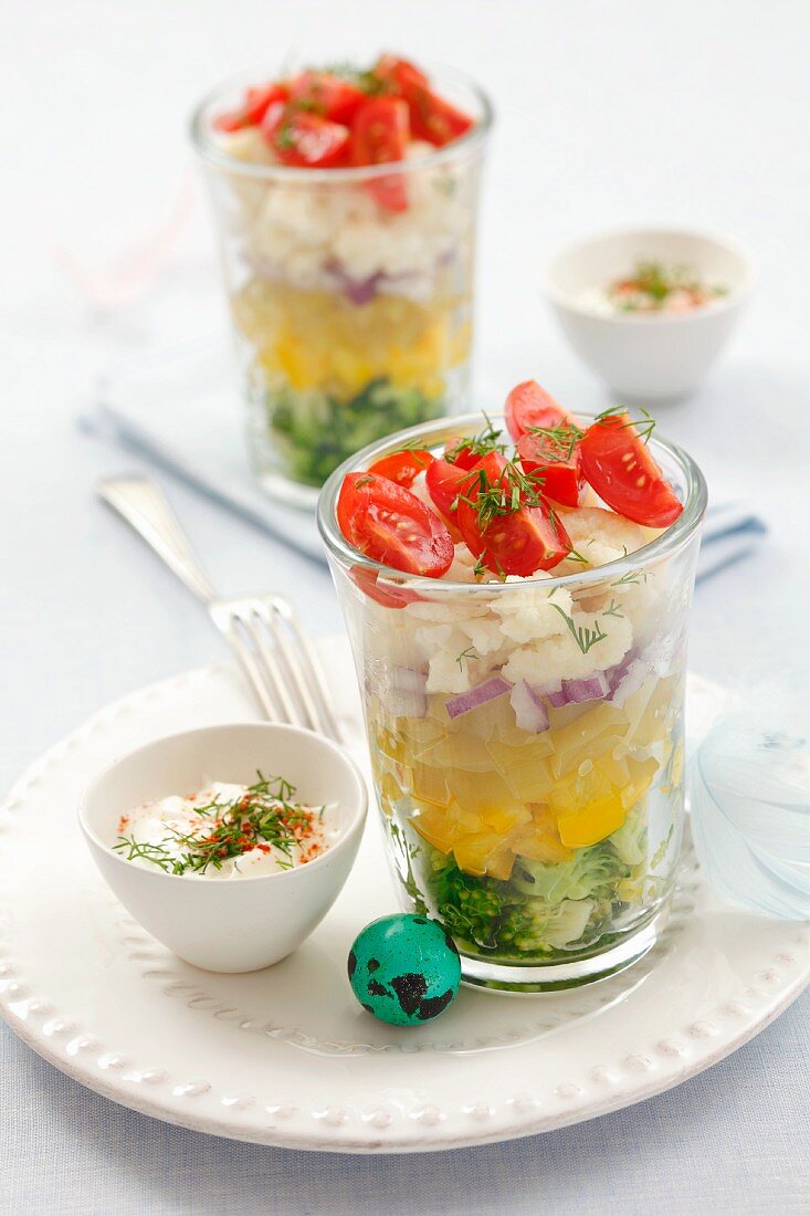 Layered vegetable salad in glasses, yoghurt dressing