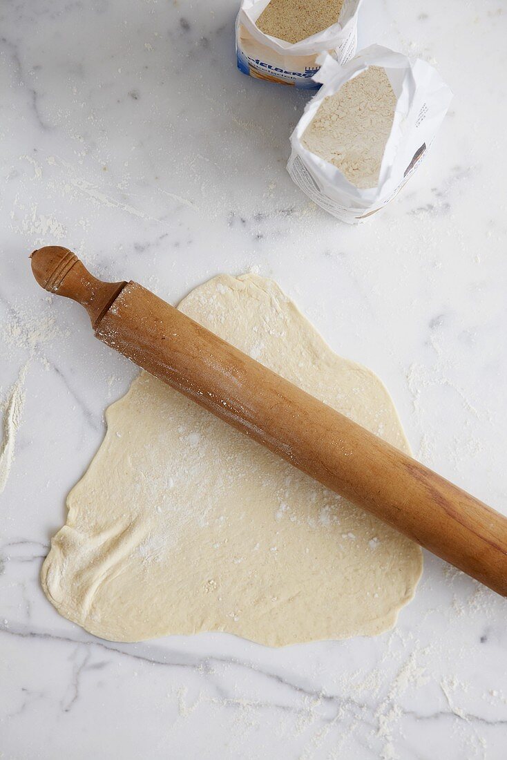 Dough with rolling pin, flour and semolina
