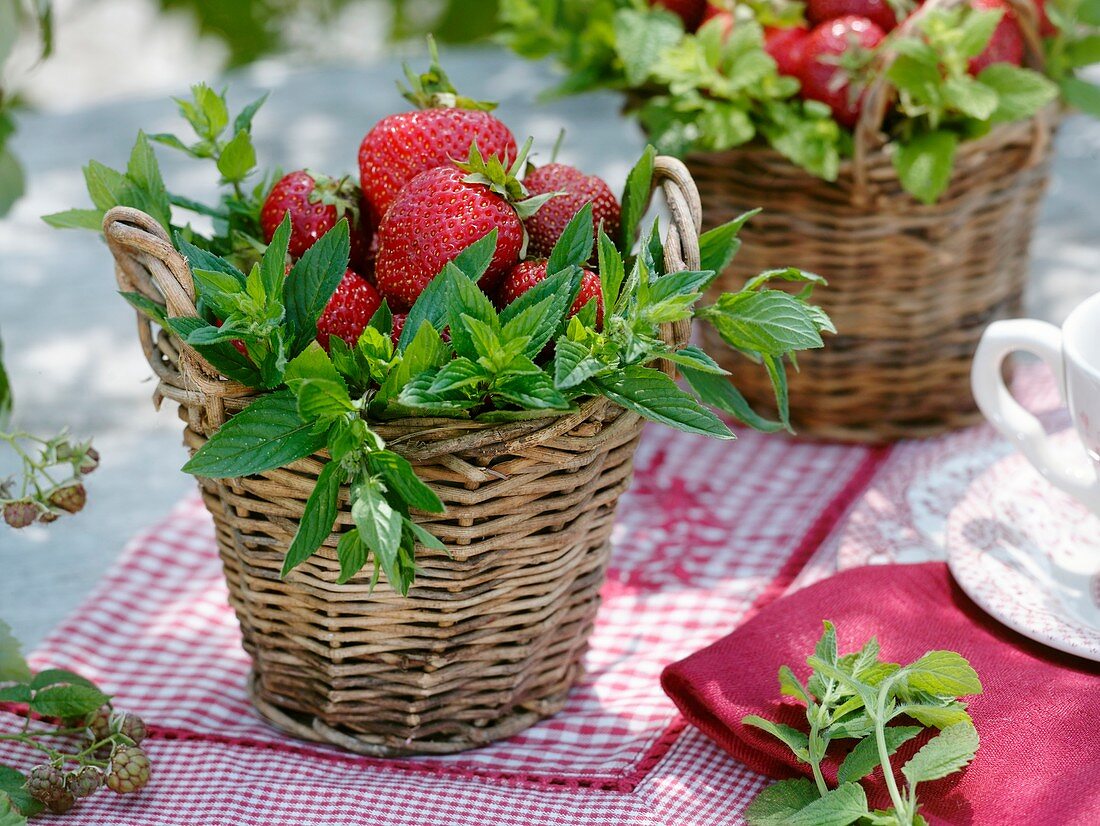 Essbare Tischdeko: Erdbeeren und frische Minze in Weidenkörben