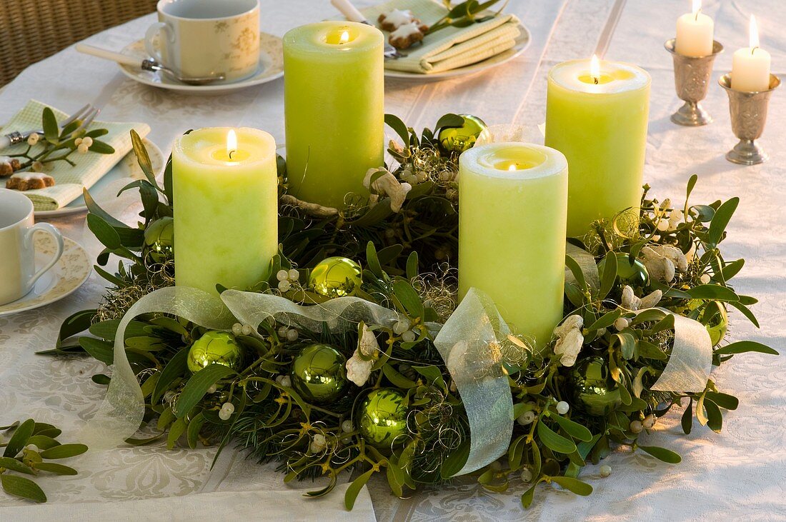Advent wreath of mistletoe and spruce with green candles