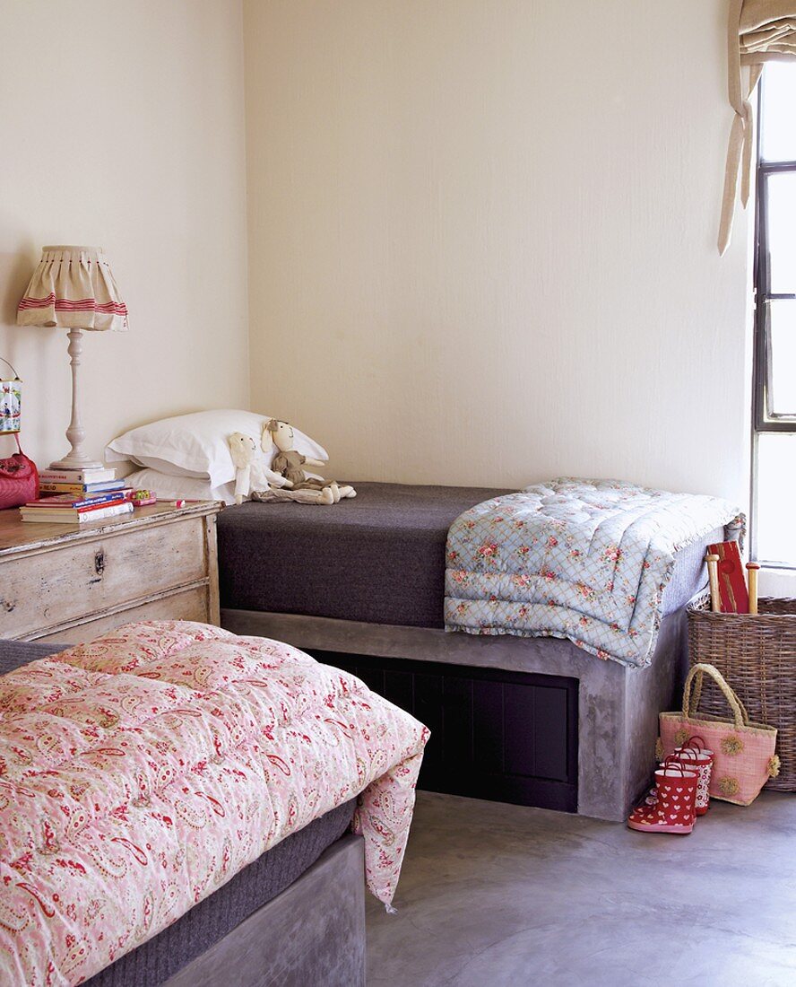 Kinderzimmer mit gemusterten Steppdecken in Pastellfarben auf den Betten