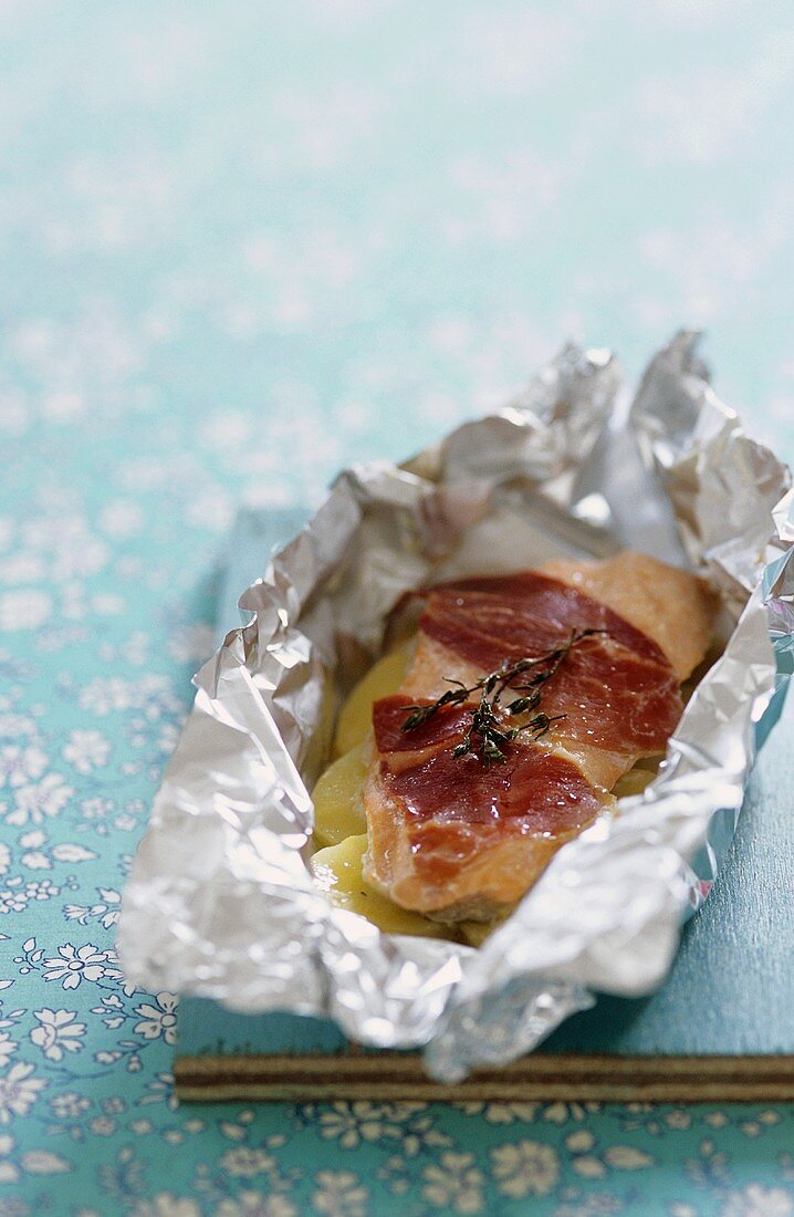 Trout fillet with raw ham and yellow carrots en papillote