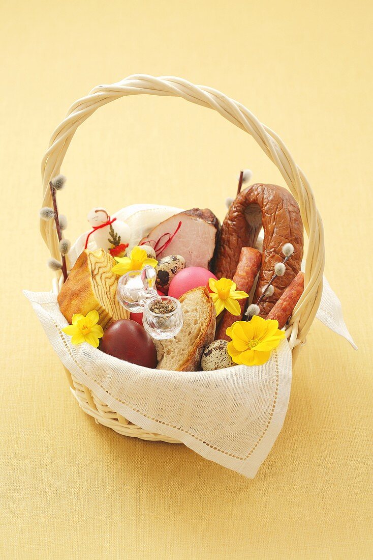 Osterkorb mit Brot, Eiern, Wurst, Schinken und Gebäck