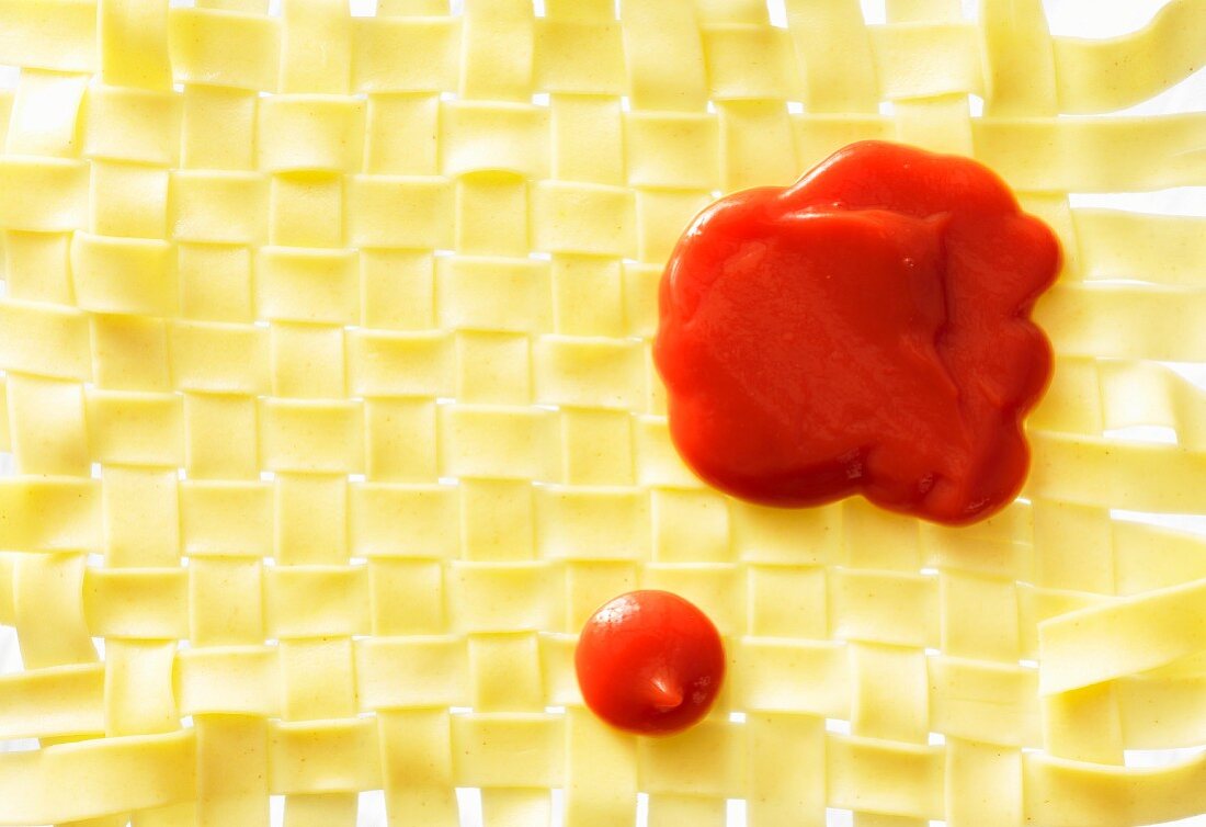Ketchup on a mat of woven pasta