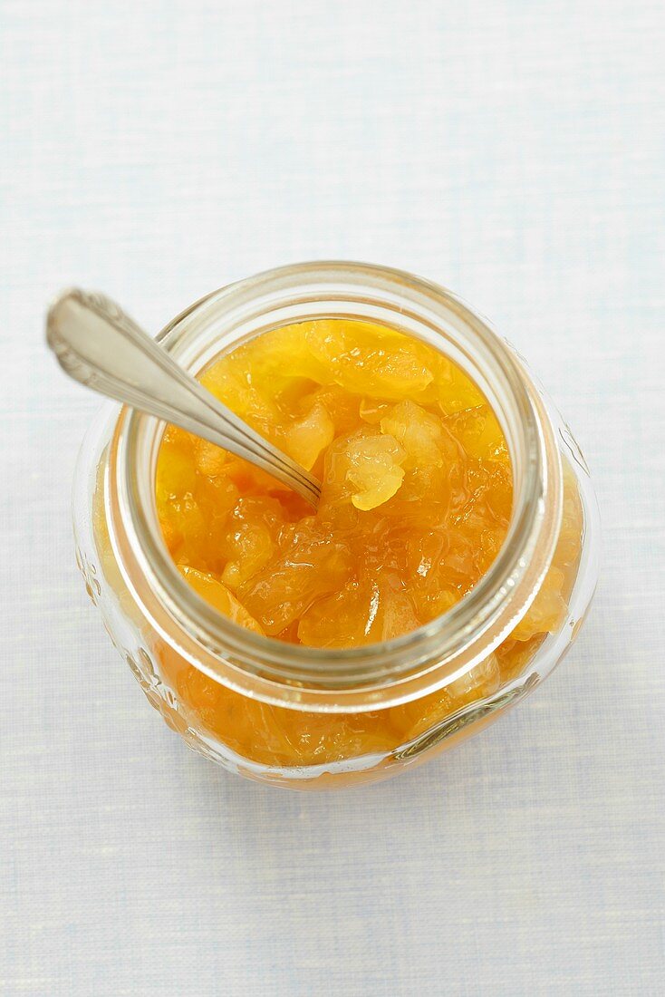 Orange marmalade in jar with spoon