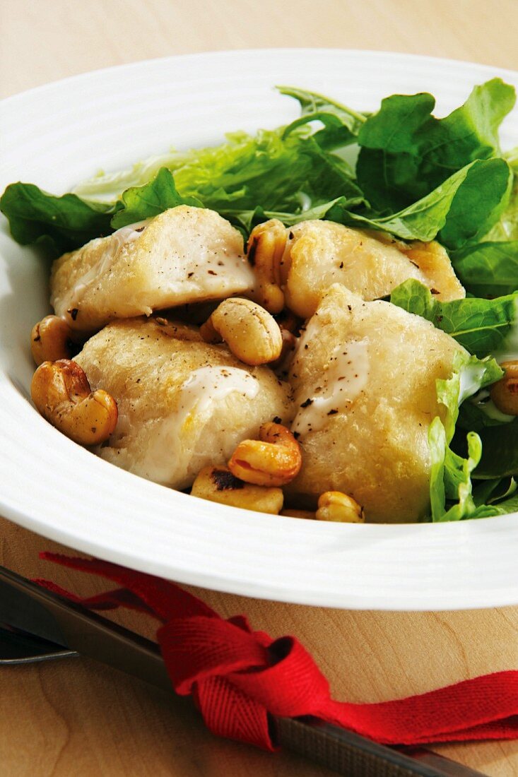 Fish with lettuce, cashew nuts and cheese dressing