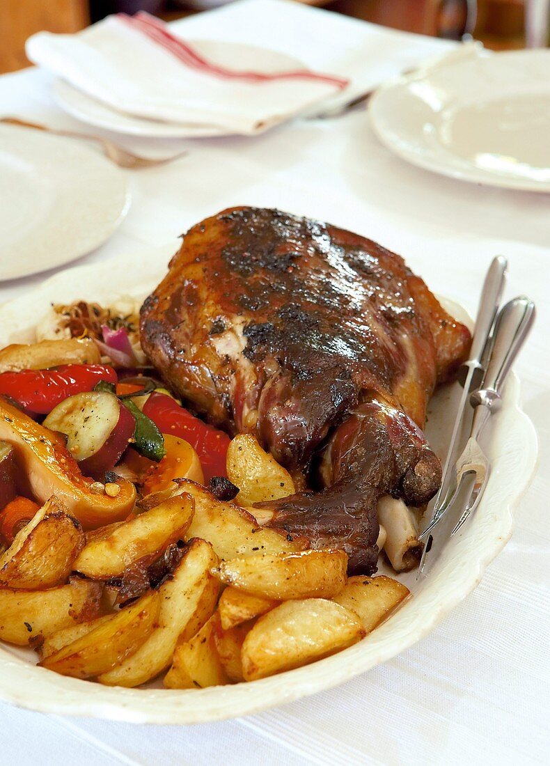 Leg of lamb with garlic, anchovies, capers and potatoes