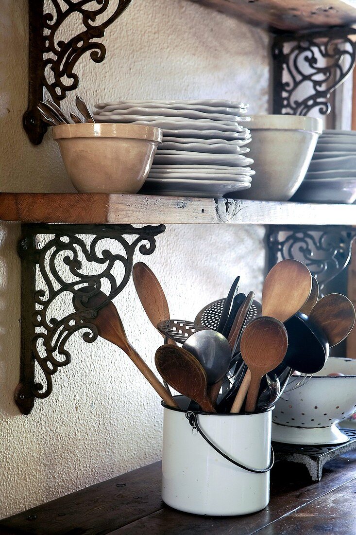 Crockery and wooden spoons on shelves