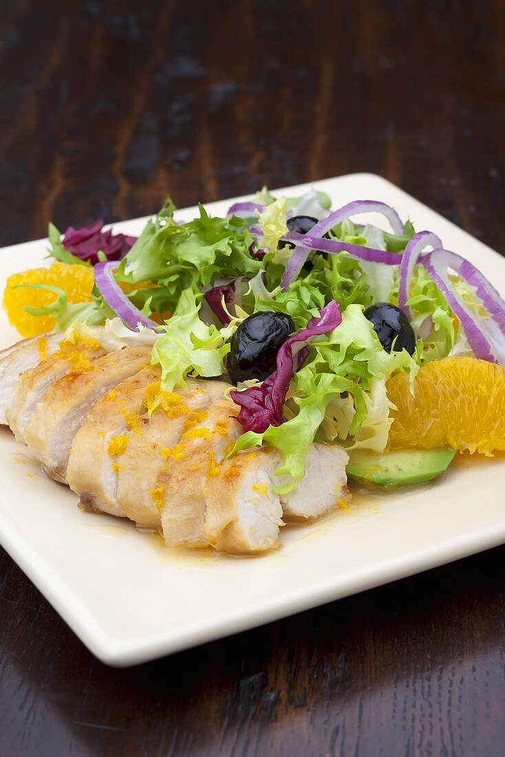 Chicken breast with salad leaves and orange segments