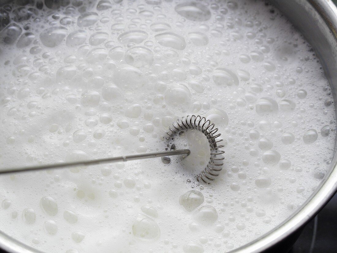 Frothing milk with a whisk