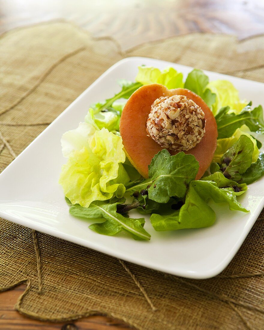 Salad leaves with pear and nut-coated goat's cheese ball