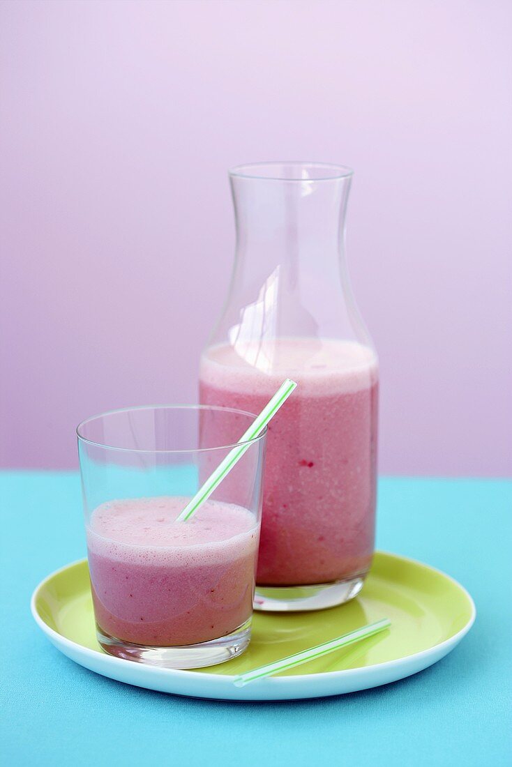 Raspberry smoothie in glass and carafe